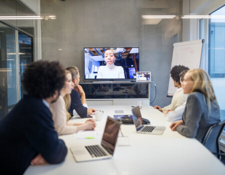 Group of business people having video conference in boardroom. Diverse business professionals having video conference meeting in office.